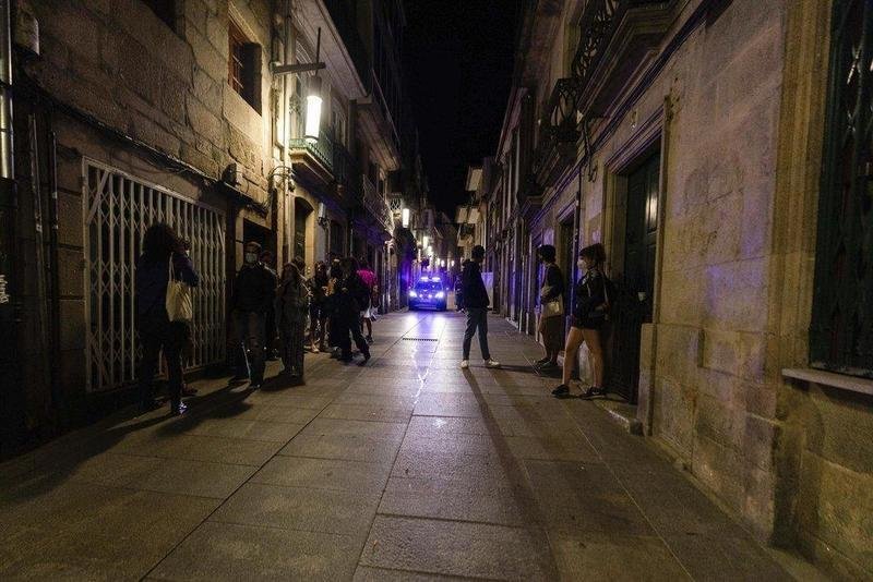  Un coche de policía pasa frente a varias personas en ambiente festivo, a 10 de julio de 2021, en Pontevedra, Galicia (España) - Beatriz Ciscar - Europa Press 