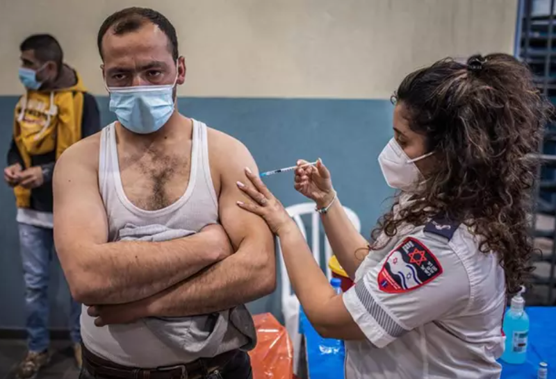  Archivo - Un trabajador palestino con permiso de trabajo en Israel recibe una dosis de la vacuna contra el coronavirus 