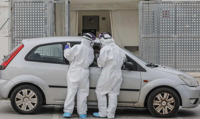  Dos sanitarios realizan una prueba PCR a una persona desde su vehículo en una imagen de archivo. - Rober Solsona - Europa Press 