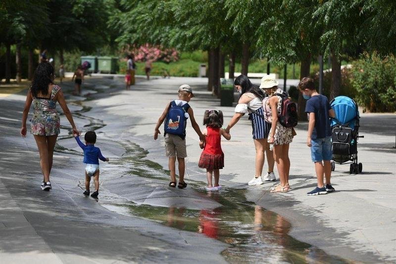  Varios niños pasan por un arroyo de agua en el Parc Central, a 12 de agosto de 2021, en Valencia, Comunidad Valenciana (España). Como consecuencia de la ola de calor que comenzó ayer en toda España, la Comunitat Valenciana alcanzará durante la jornada de - Jorge Gil - Europa Press 