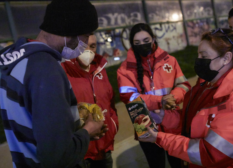 Archivo - Varios trabajadores de Cruz Roja ofrecen comida a un hombre sin hogar - Jesús Hellín - Europa Press - Archivo 