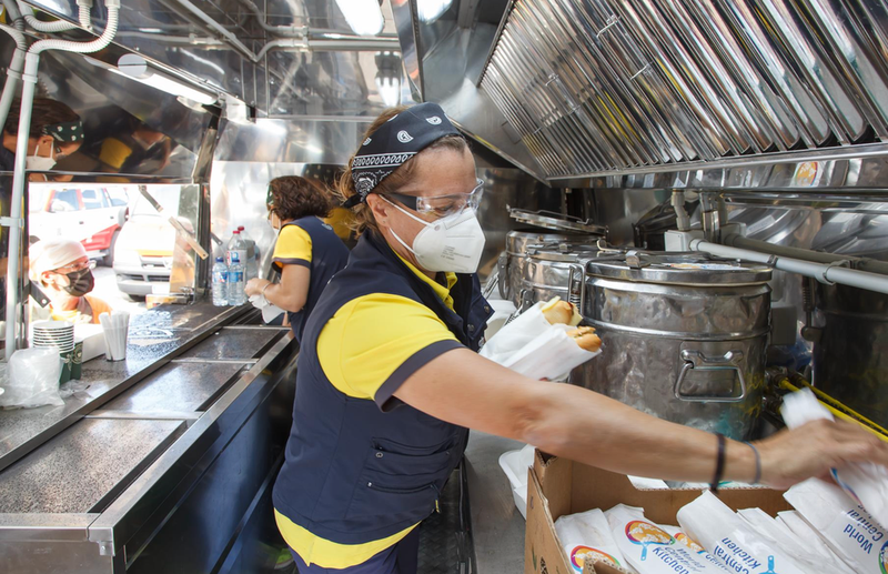 <p> Voluntarias de World Central Kitchen, la ONG del chef José Andrés, reparten comida entre los trabajadores y voluntarios que asisten a los afectados por el volcán de Cumbre Vieja - Europa Press </p>