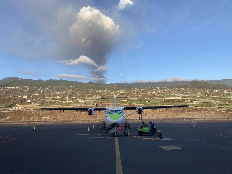 <p> Un avión de Binter en la pista del aeropuerto de La Palma, con el volcán en erupción al fondo - BINTER </p>