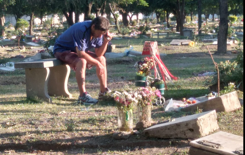 <p> Imagen del momento, el padre junto a la tumba de su hijo </p>