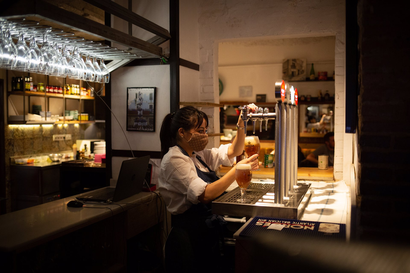 <p> Una camarera sirve una cerveza en el interior de un bar - David Zorrakino - Europa Press </p>