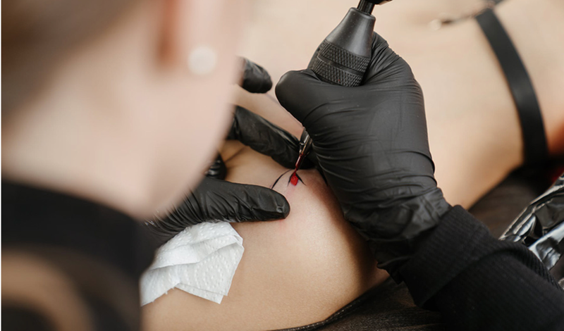 <p> Un profesional realiza un tatuaje sobre la piel de un cliente. </p>