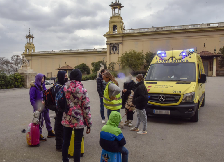 <p> Varios refugiados y una traductora, junto a una ambulancia, en la entrada del palacio de Victoria Eugenia, el palacio 7 de Fira de Barcelona, convertido en un centro de recepción - David Oller - Europa Press </p>