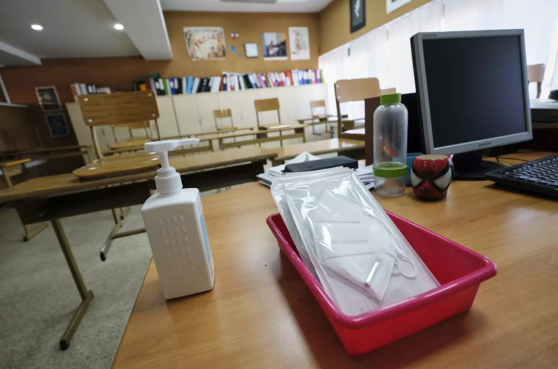 <p> Mascarillas y gel desinfectante en la mesa del profesor de un aula. Fuente: Europa Press </p>