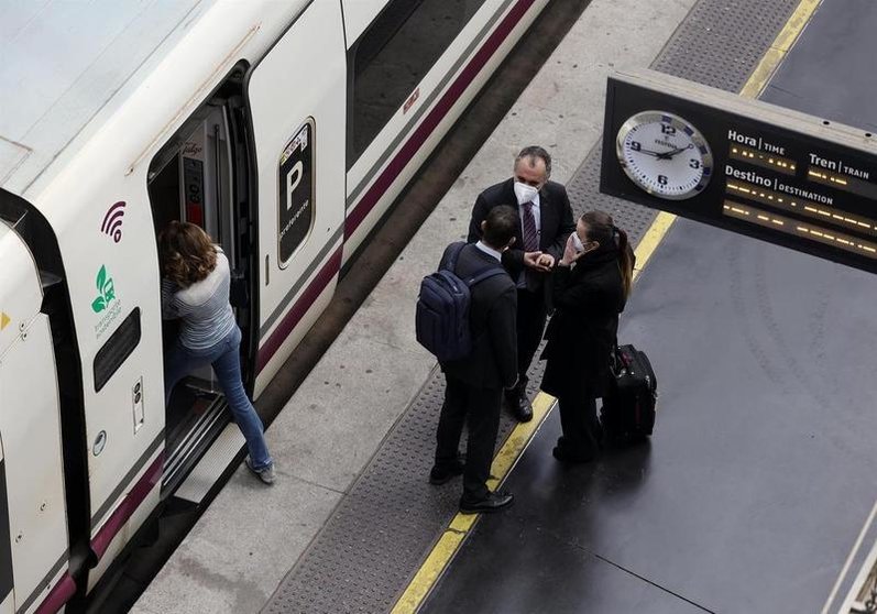 <p> Varias personas, con maletas, en el andén antes de coger un tren de alta velocidad </p>