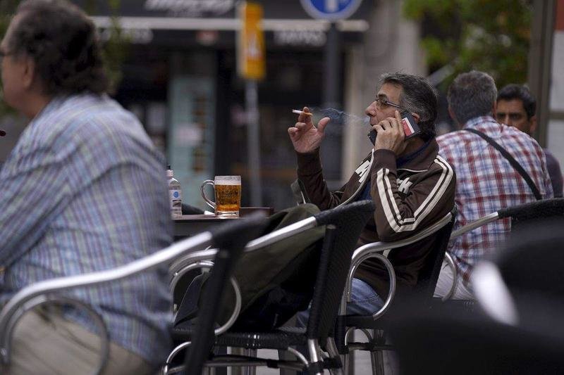 <p> Una persona fumando en una terraza </p>