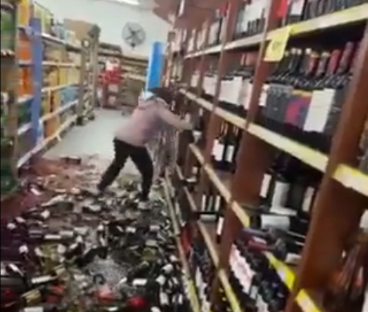<p> Captura del vídeo donde la mujer tira botellas de vino </p>