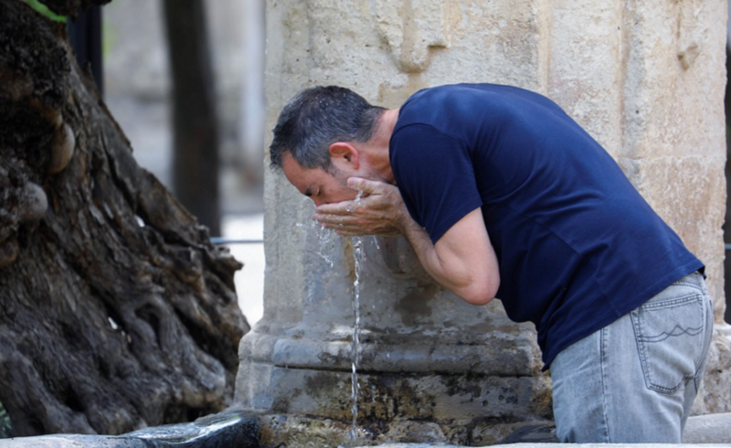 <p> Un hombre bebe agua de una fuente en Córdoba </p>