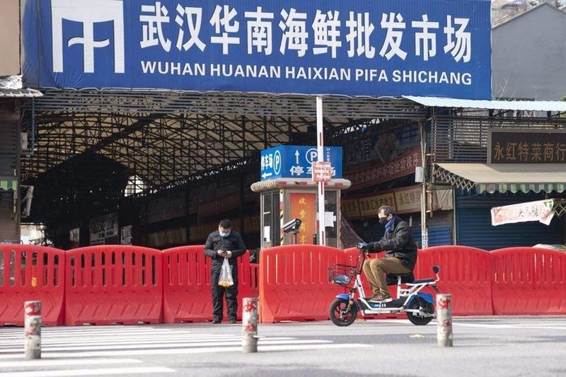 <p> Dos ciudadanos pasan por la entrada del mercado de mariscos Huanan en Wuhan, provincia de Hubei, en el centro de China, el 29 de enero </p>