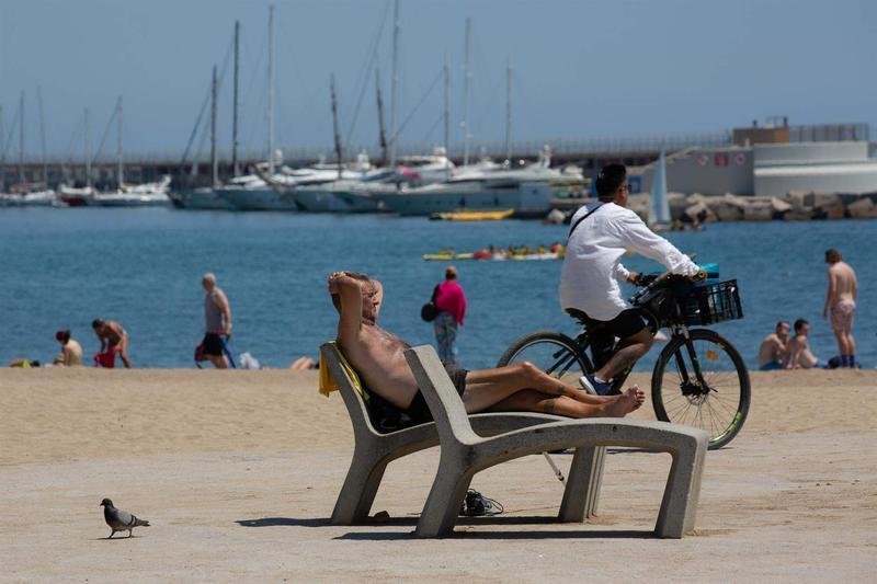 <p> Varias personas toman el sol en la playa de la Barceloneta, a 13 de julio de 2022 </p>
