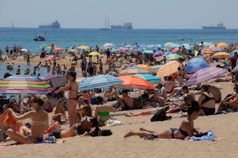 <p> Varias personas se protegen del sol en la playa de la Barceloneta, a 13 de julio de 2022, en Barcelona, Catalunya (España). La intensa y extensa ola de calor llega hoy a su momento cumbre, aunque ese pico se mantendrá durante varios días seguidos, según l - David Zorrakino - Europa Press </p>