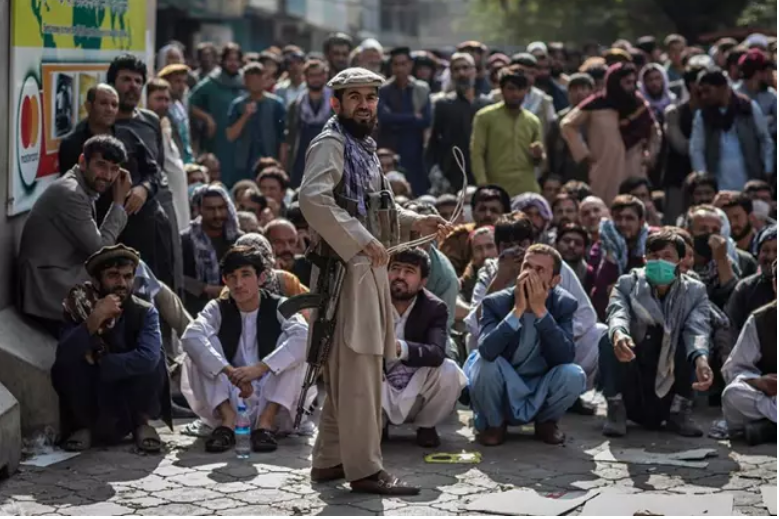 <p> Miliciano talibán guarda la cola para retirar dinero </p>