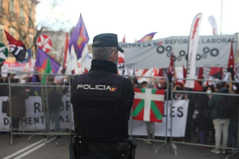 <p> Un policía nacional vigila la cabecera de una concentración frente al Congreso de los Diputados </p>