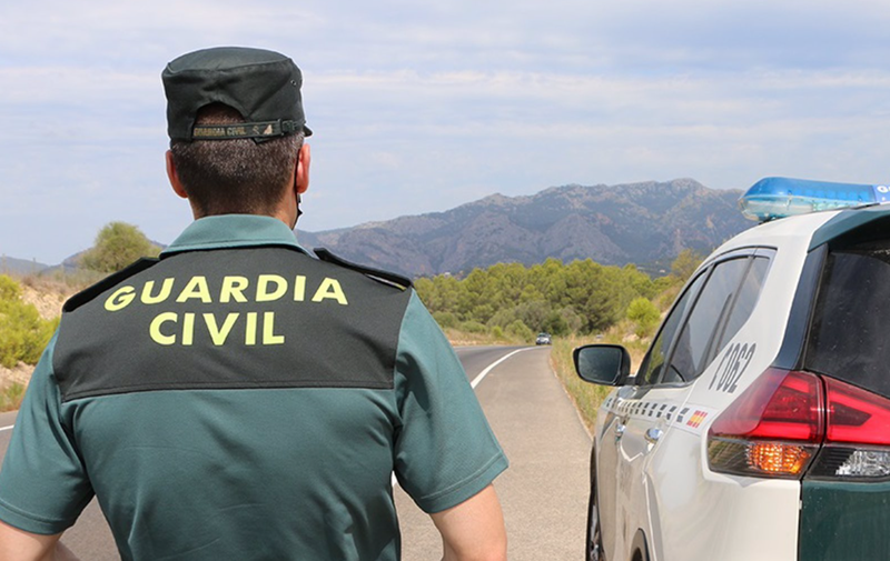  Archivo - Un agente de la Guardia Civil junto a un vehículo en una carretera. (Foto de archivo). - GUARDIA CIVIL - Archivo 