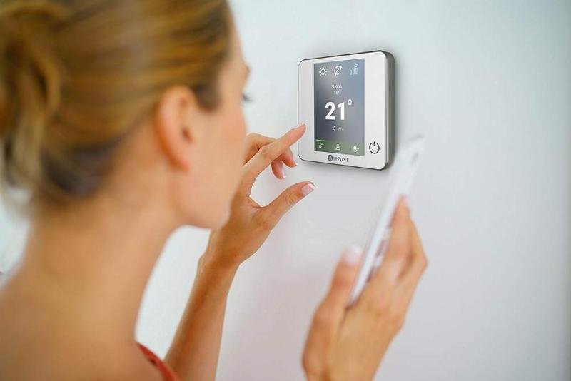 Una mujer regula el termostato 