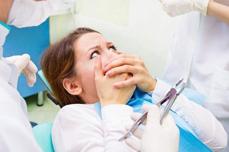  Joven con miedo en el dentista 