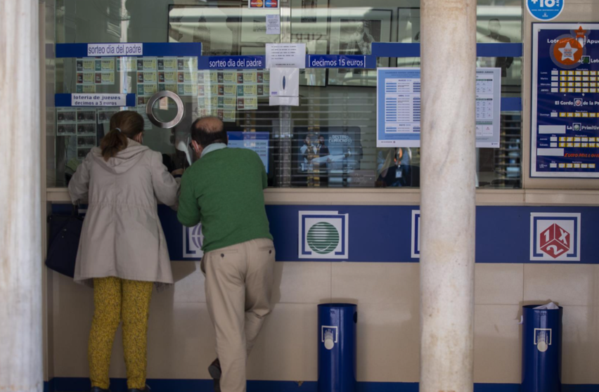  Archivo - Dos personas compran lotería en una Administración durante el primer día del proceso de desescalada instaurado por el Gobierno en el que los sorteos de EuroMillones y La Primitiva se reanudan en la semana del 18 al 24 de mayo, mientras que los d - María José López - Europa Press - Archivo 