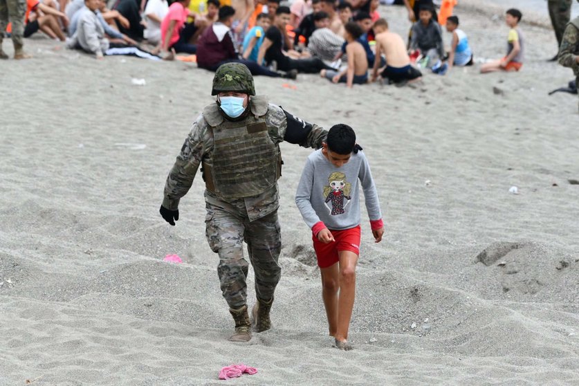  Un militar del ejército español acompaña a un niño 