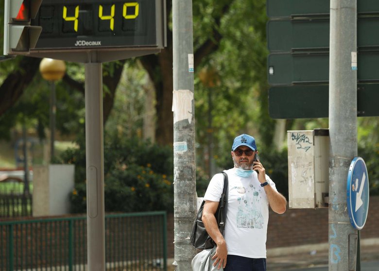  Un hombre habla por el móvil junto a un termómetro que marca 44º 