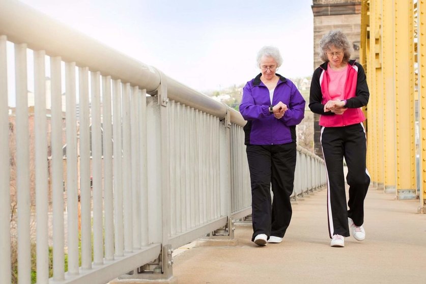  Mujeres mayores andando comprobando sus pulsaciones 