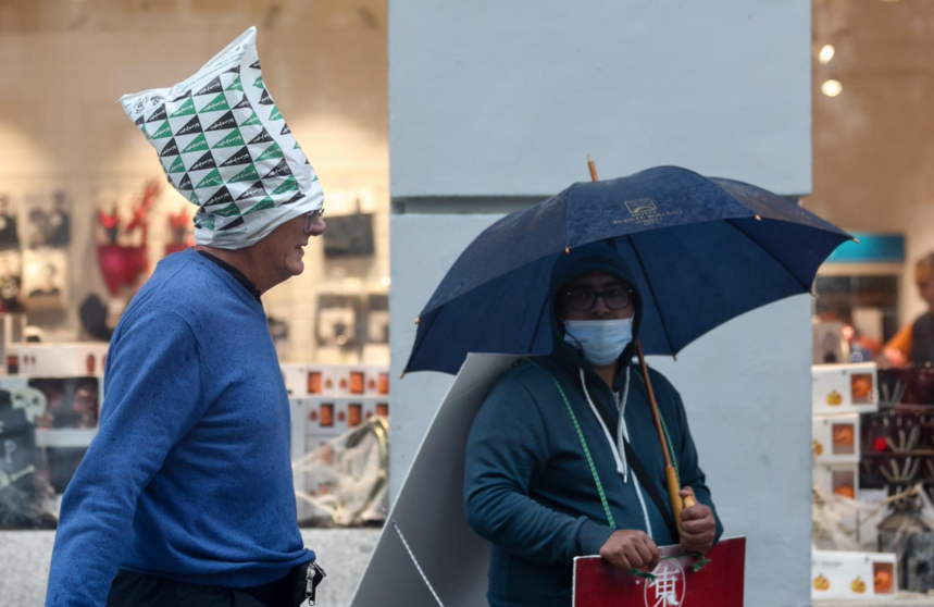  Archivo - Un hombre se cubre la cabeza con una bolsa de plástico para cubrirse de la lluvia, en la calle Gran Vía, a 20 de octubre, en Madrid (España). - Eduardo Parra - Europa Press - Archivo 