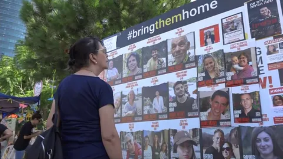 Una mujer frente a los carteles de desaparecidos por Hamás 