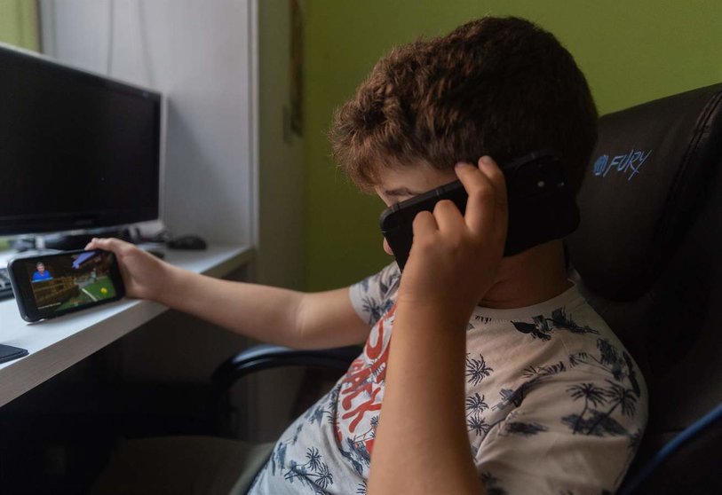  Un niño usa el teléfono para ver vídeos 