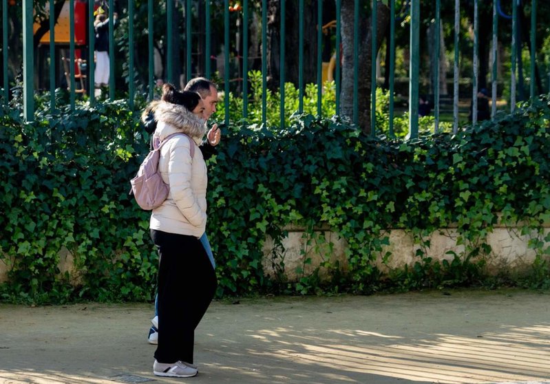  Personas abrigadas pasean por el Parque de María Luisa, en un día frío y el soleado a la vez, a 27 de diciembre del 2023 en Sevilla (Andalucía, España). - Eduardo Briones - Europa Press 