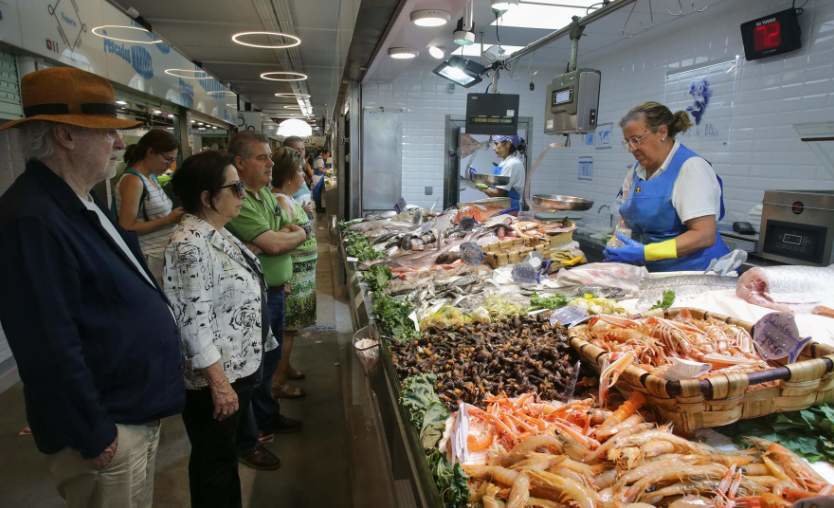  Varias personas comprando alimentos en un mercado 