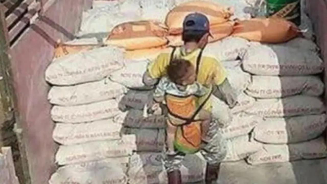  El alba&ntilde;il carga con su hijo a la espalda mientras trabaja. 