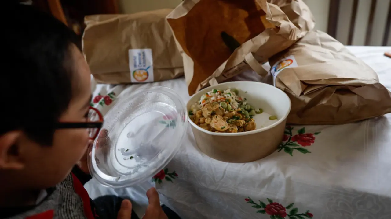 Un ni&ntilde;o durante la comida en su casa del barrio madrile&ntilde;o de Carabanchel abre la tapa de un plato del men&uacute; de la ONG del chef Jos&eacute; Andr&eacute;s, en Madrid (Espa&ntilde;a)  - Jes&uacute;s Hell&iacute;n - Europa Press - Archivo