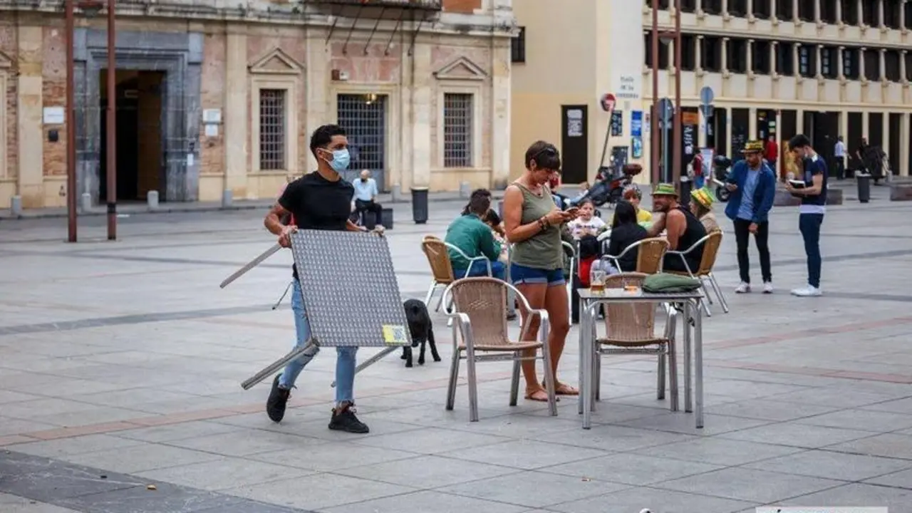  Un camarero recoge una de las terrazas en La Corredera, C&oacute;rdoba. | Jos&eacute; Le&oacute;n. 