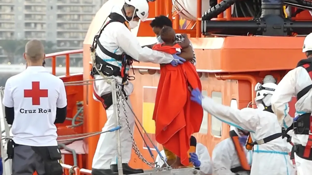  Un miembro de la Cruz Roja ayuda a bajar del barco a una mujer migrante con su ni&ntilde;o en el puerto de Arguinegu&iacute;n - Europa Press 