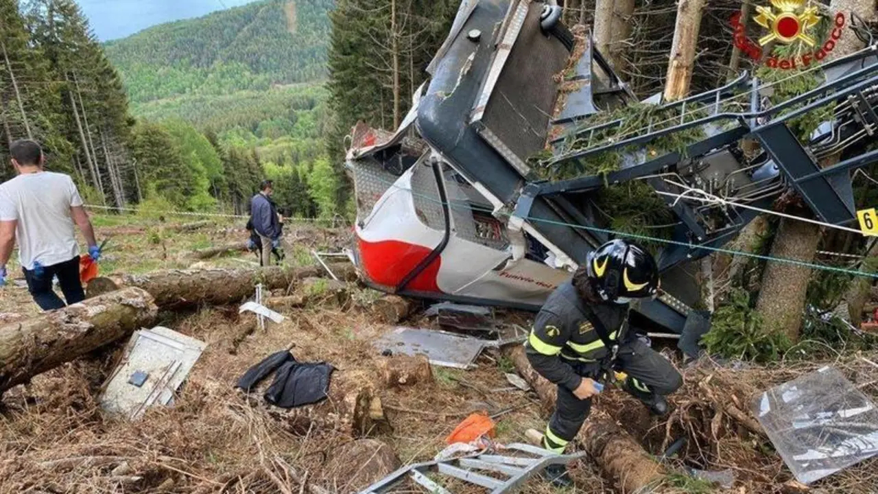 Rescuers work by the wreckage of a cable car after it collapsed near the summit of the Stresa-Mottarone line in the Piedmont region, northern Italy, Sunday, May 23, 2021. A cable car taking visitors to a mountaintop view of some of northern Italy's most picturesque lakes plummeted to the ground Sunday and then tumbled down the slope, killing at least 13 people and sending two children to the hospital, authorities said. (Italian Vigili del Fuoco Firefighters via AP)