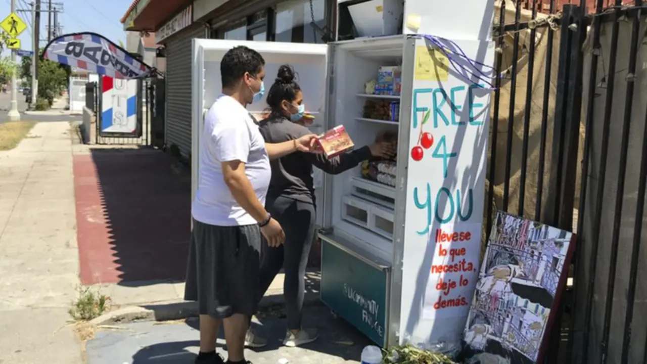  Vecinos depositando comida en una de las neveras comunitarias. 