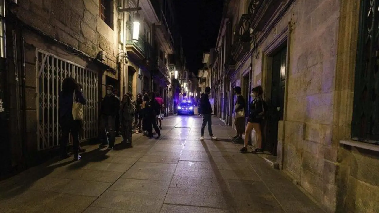  Un coche de polic&iacute;a pasa frente a varias personas en ambiente festivo, a 10 de julio de 2021, en Pontevedra, Galicia (Espa&ntilde;a) - Beatriz Ciscar - Europa Press 