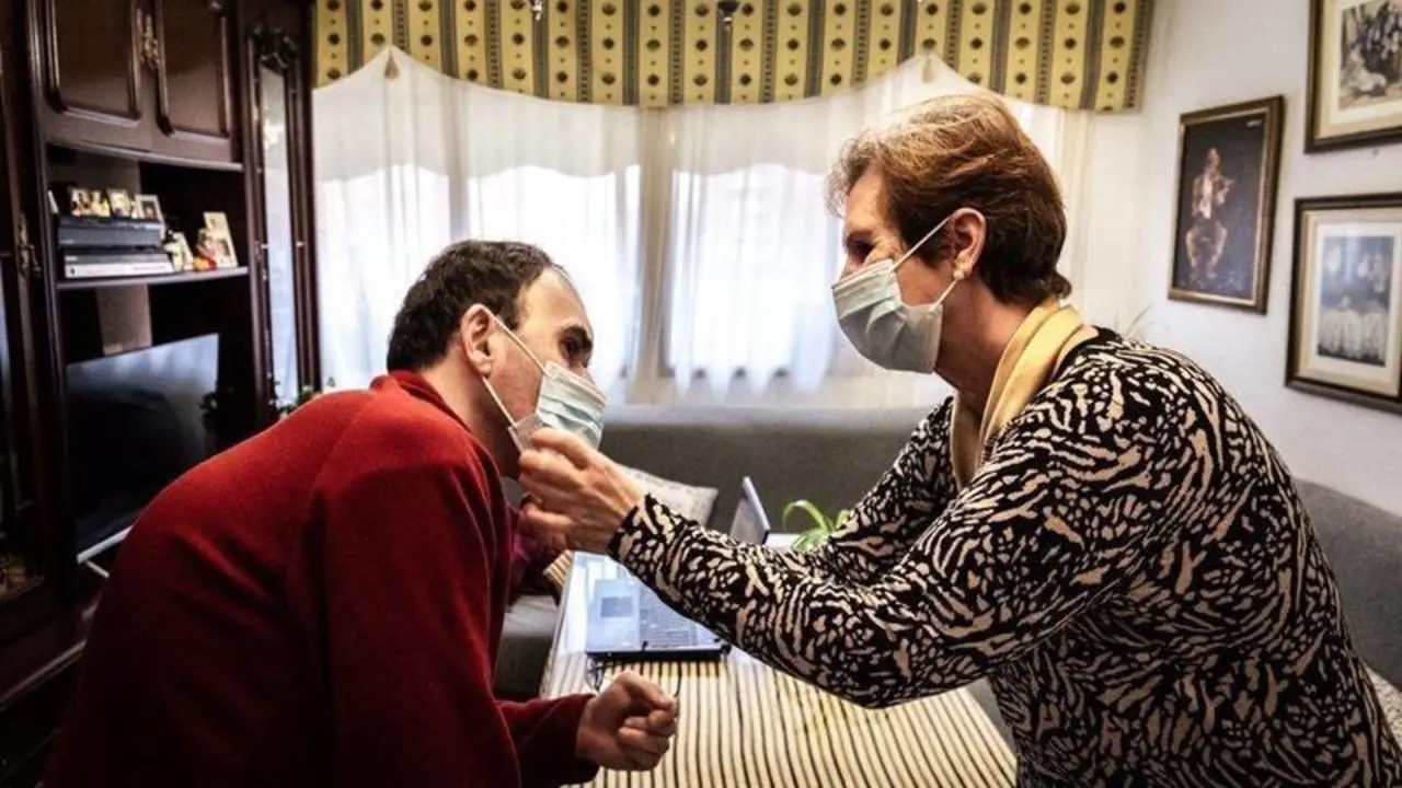  Archivo - Una mujer ayuda a su hijo con discapacidad a colocarse la mascarilla. - ROBERTO PALOMO - Archivo 