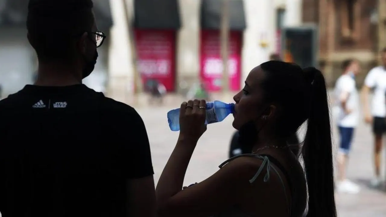  Varias personas intentan protegerse del calor en el d&iacute;a donde la capital andaluza se encuentra en aviso naranja por temperaturas que superar&aacute;n los 40 grados en algunos puntos de la capital y la provincia a 12 de julio del 2021 en M&aacute;laga (Andaluc&iacute;a). - &Aacute;lex Zea - Europa Press 