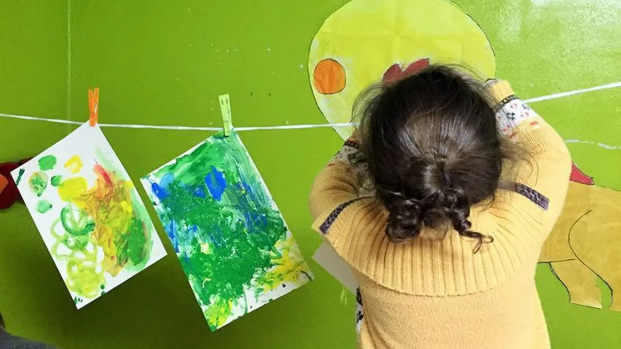  Una ni&ntilde;a cuelga sus pinturas para que se sequen en una casa de acogida para v&iacute;ctimas de violencia de g&eacute;nero. 