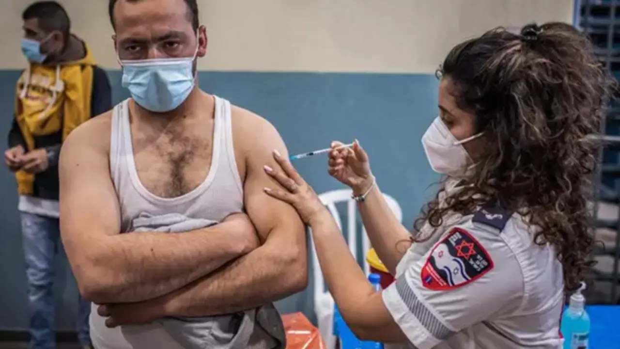  Archivo - Un trabajador palestino con permiso de trabajo en Israel recibe una dosis de la vacuna contra el coronavirus 