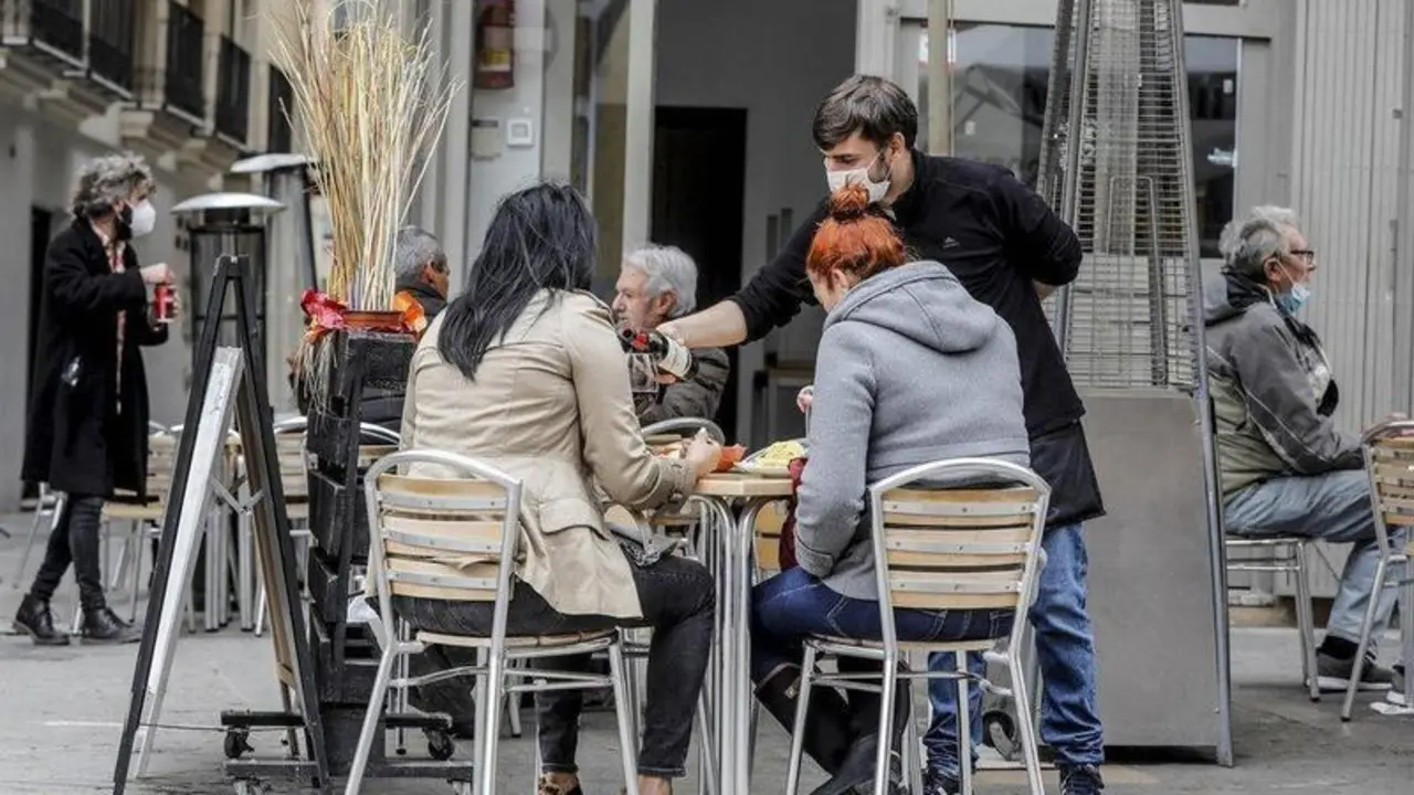  Un camarero atiende a dos clientas en una terraza el primer d&iacute;a de la apertura de la hosteler&iacute;a. EP 