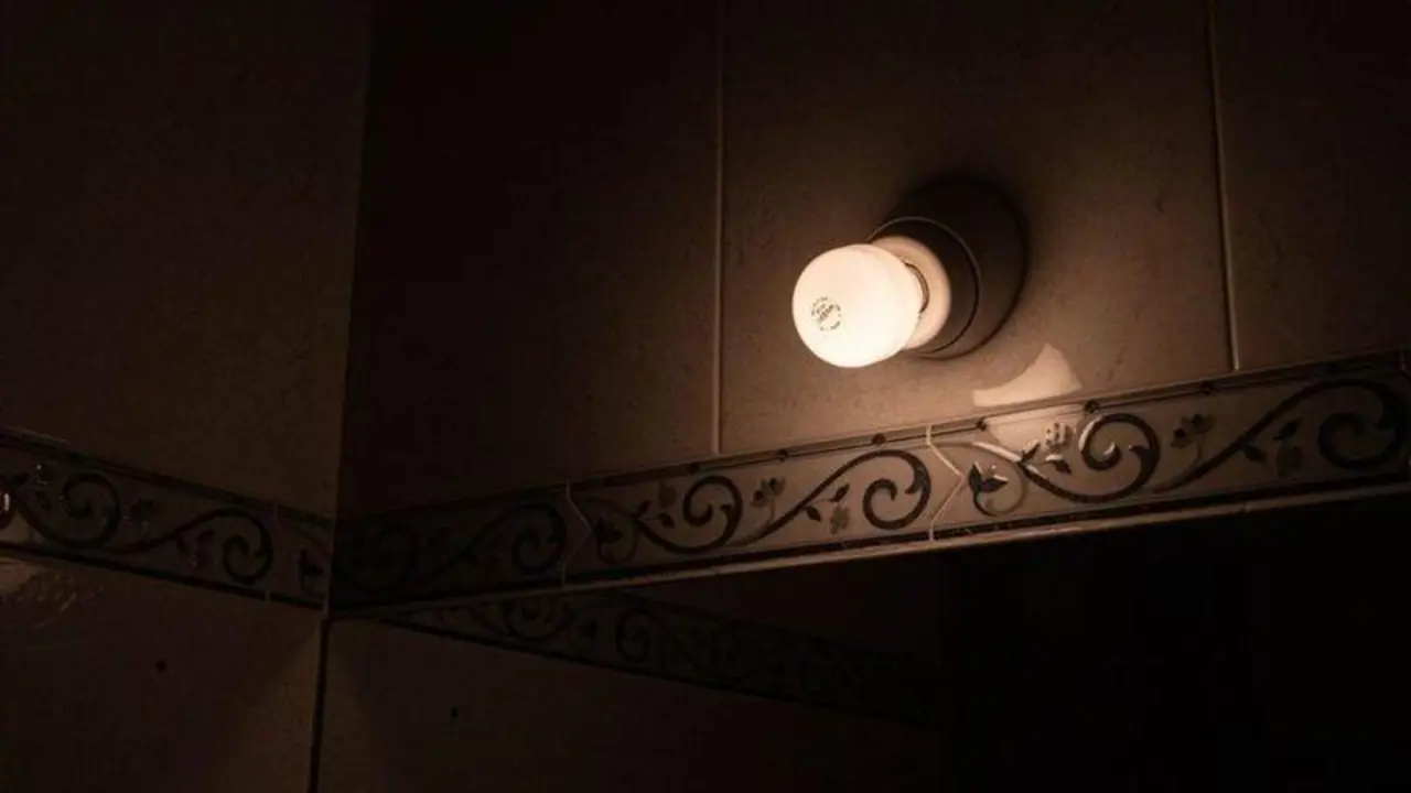  Una l&aacute;mpara se mantiene encendida en el interior de una casa. 