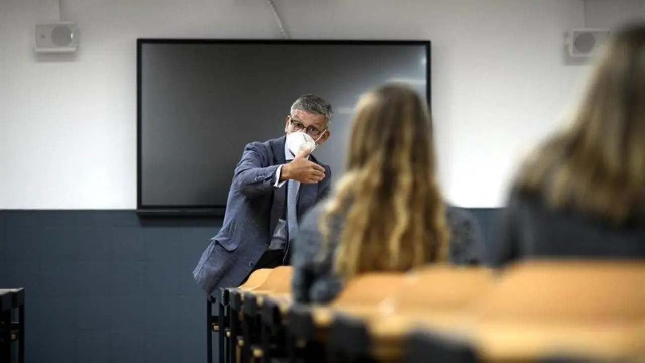  Un profesor da clase con mascarilla 