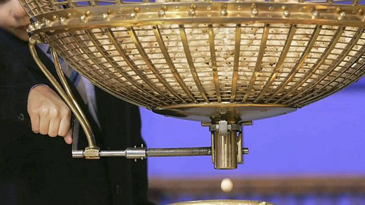 A boy from a school that was once an orphanage, lets a winning prize ball fall during the Christmas Lottery draw in Madrid, Saturday Dec. 22, 2007. Raul Barrak and Alvaro Lopez Guerrero, children from a school that was once an orphanage, had the privilege of reading out the Christmas lottery prize number which was 06381 before 11 am (1000 GMT). The complex sweepstake, held in a televised ceremony brings Spain to a standstill, with an estimated three of every four Spaniards holding tickets for what is billed as one of the world's richest lottery. The lottery shuns jackpots in favor of a share-the-wealth system in which thousands of numbers yield at least some degree of Christmas mirth, ranging from the face value of a 20-euro ticket, through a series of more lucrative but lower-level winnings all the way up to the first-prize number, called El Gordo. (AP Photo/Bernat Armangue)