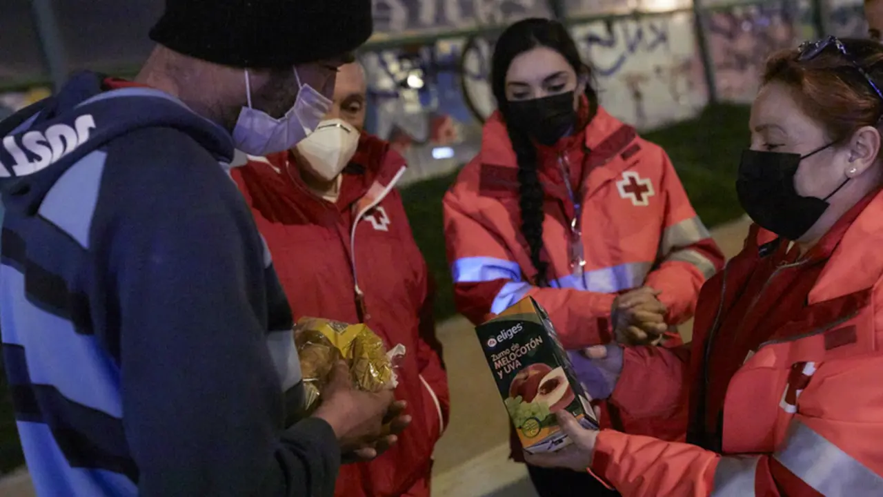  Archivo - Varios trabajadores de Cruz Roja ofrecen comida a un hombre sin hogar - Jes&uacute;s Hell&iacute;n - Europa Press - Archivo 
