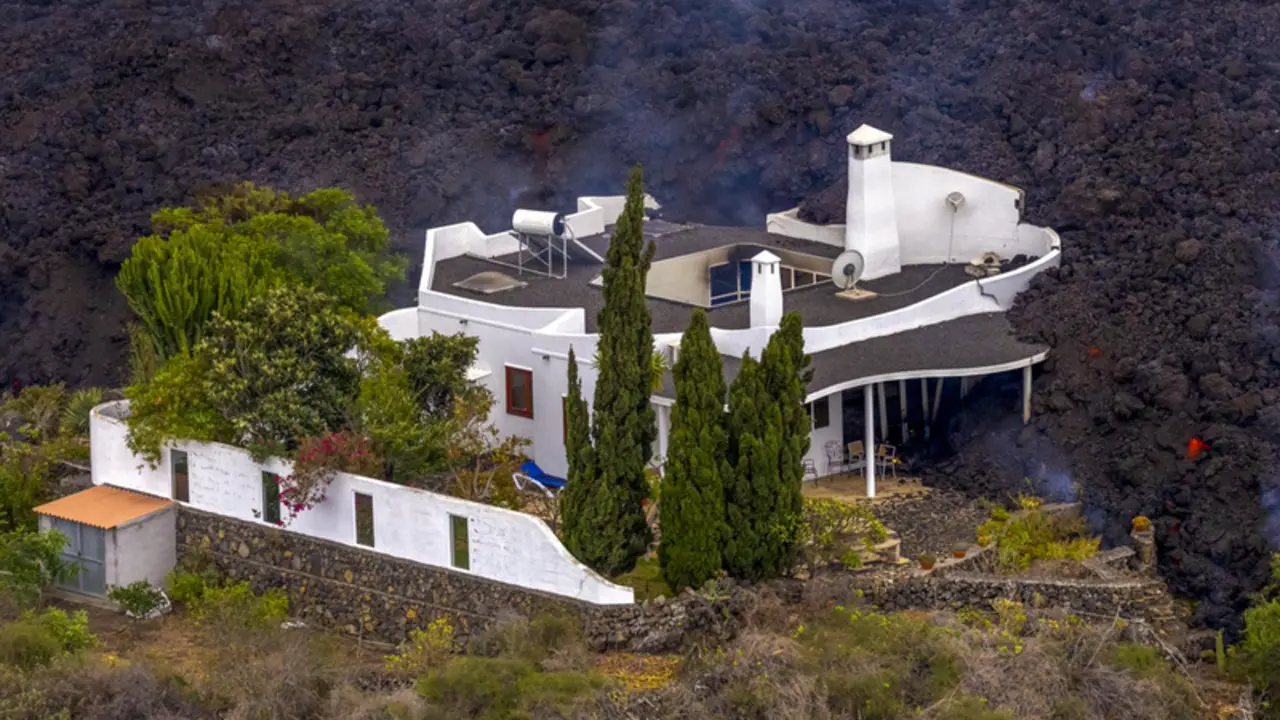 <p> Una casa momentos antes de ser destrozada por la lava del volc&aacute;n de La Palma, a 21 de septiembre de 2021, en La Palma, Santa Cruz de Tenerife, Canarias (Espa&ntilde;a). El r&iacute;o de lava del volc&aacute;n de &lsquo;Cumbre Vieja&rsquo; contin&uacute;a avanzando hacia el mar, aunque en las &uacute;l - Equipo I Love The World </p>